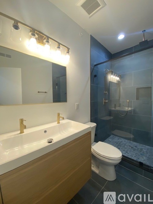 A modern bathroom with a white sink and a toilet.