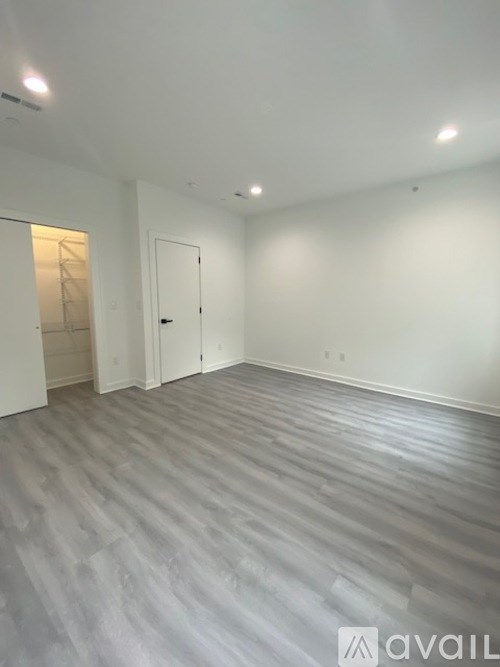 A spacious room with a grey floor and white walls.