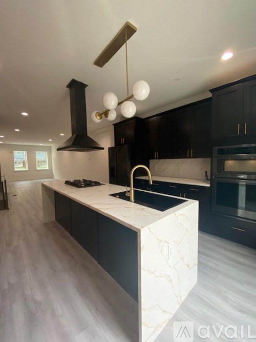 A modern kitchen with a marble island and dark wood cabinets.