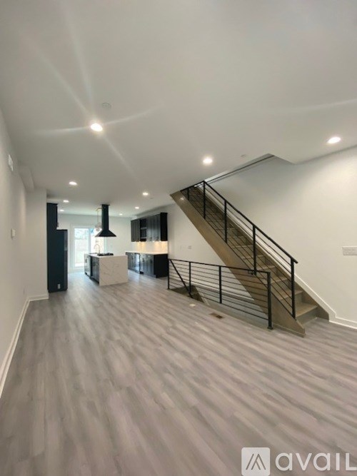 A spacious room with a staircase leading to the upper floor.