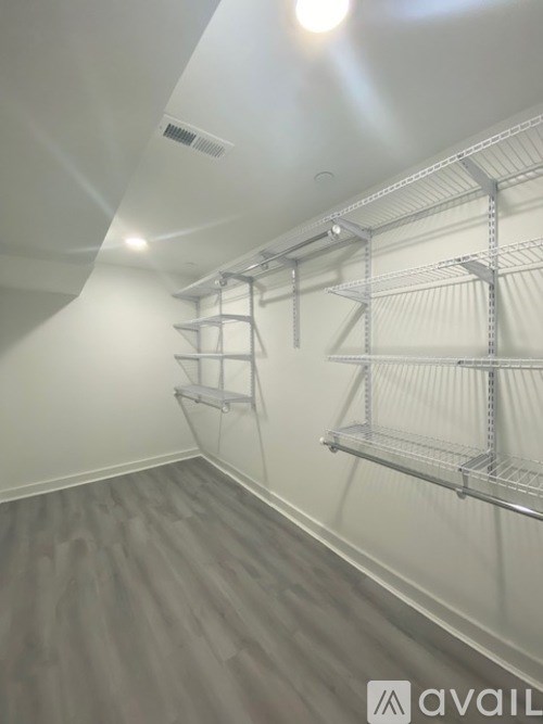 Empty shelves in a white room with wooden flooring.