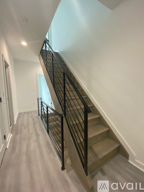 A staircase with a black railing and wooden steps.
