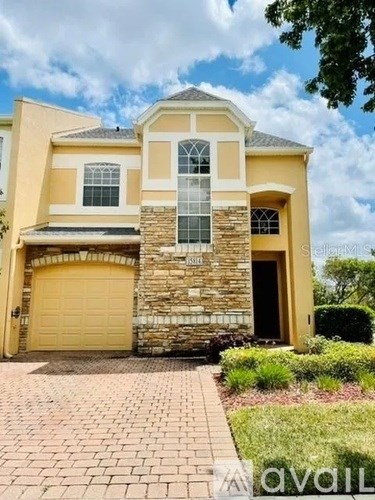 A two-story house with a stone wall and a garage door.
