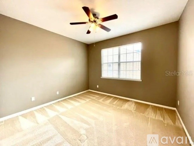 A room with a ceiling fan and a window.