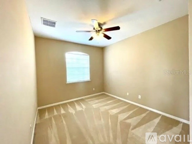 A room with a ceiling fan and a window.