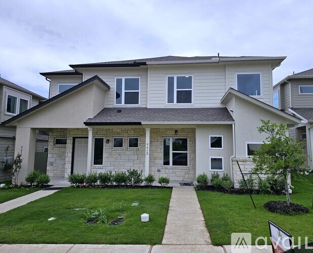 A house with a well-maintained lawn and a clear sky.