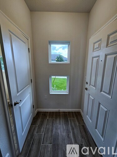 A room with a window showing a green lawn outside.