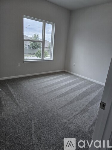 A room with a carpeted floor and a window.