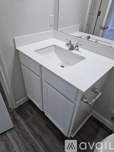 A white bathroom sink with a mirror above it.