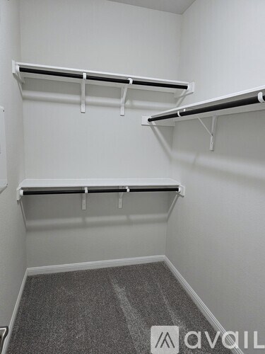 A white closet with three shelves and a grey carpet.
