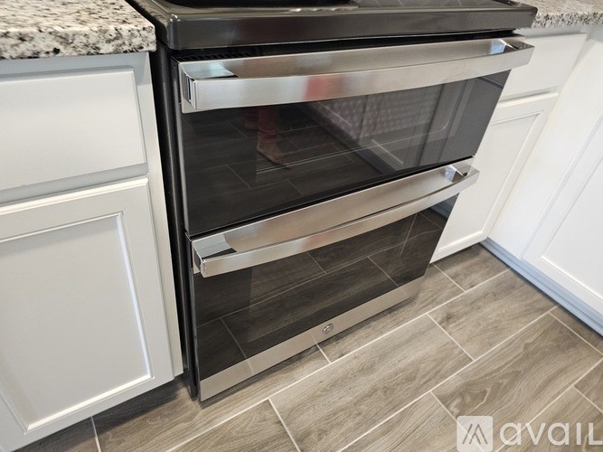 A modern stainless steel oven with a glass door is installed in a kitchen.