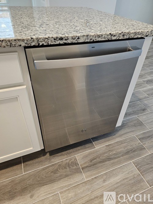 A modern kitchen with a granite countertop and a stainless steel dishwasher.