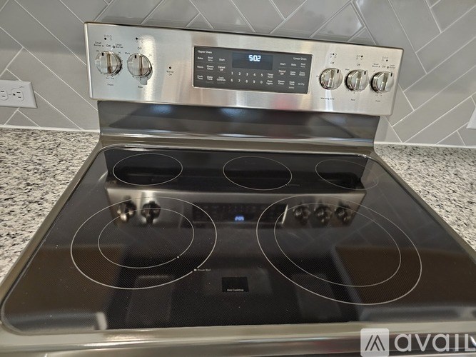 A stainless steel oven with a digital control panel and four burners.