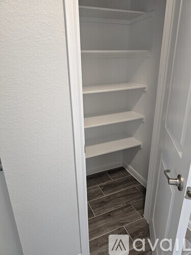 A white refrigerator with four shelves is open.