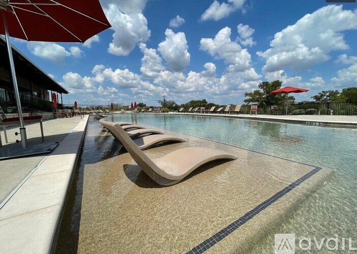 A sun lounger sits on the edge of a pool.