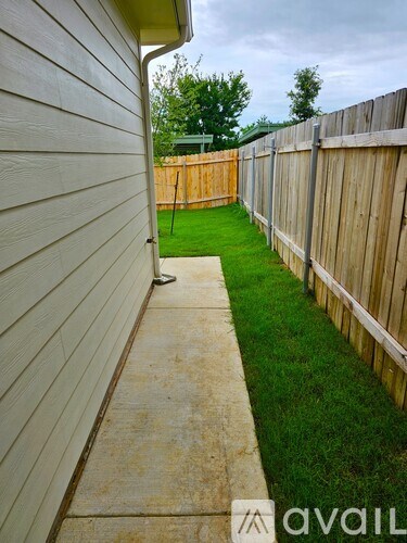 A white house with a concrete walkway leading to a green lawn.