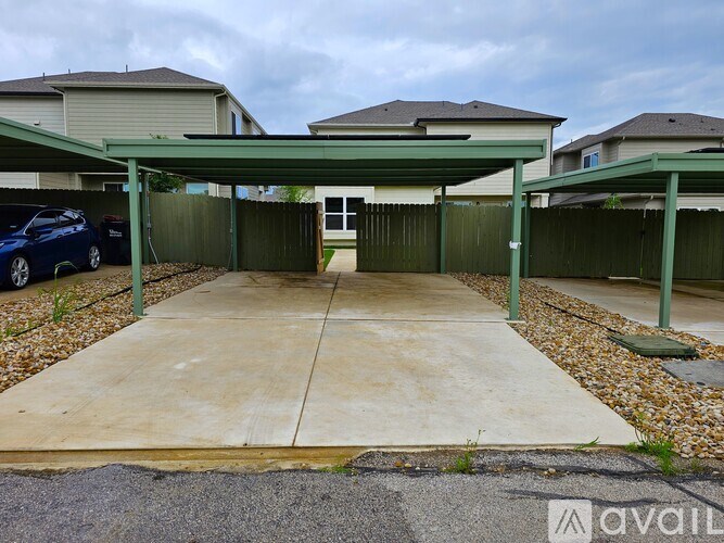 A carport with a green roof is attached to a house.