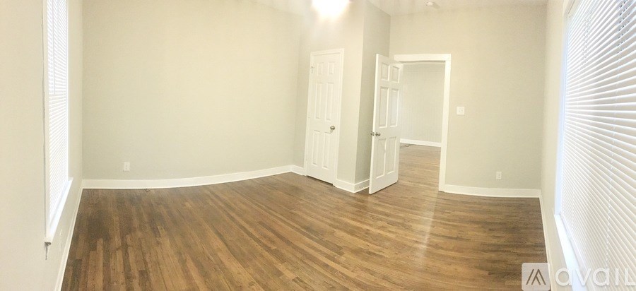 A room with wood flooring and white walls.