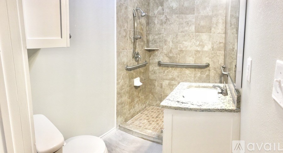 A bathroom with a toilet, sink, and shower.