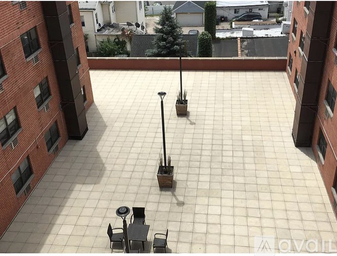 A patio with a table and chairs and a tree in a pot.