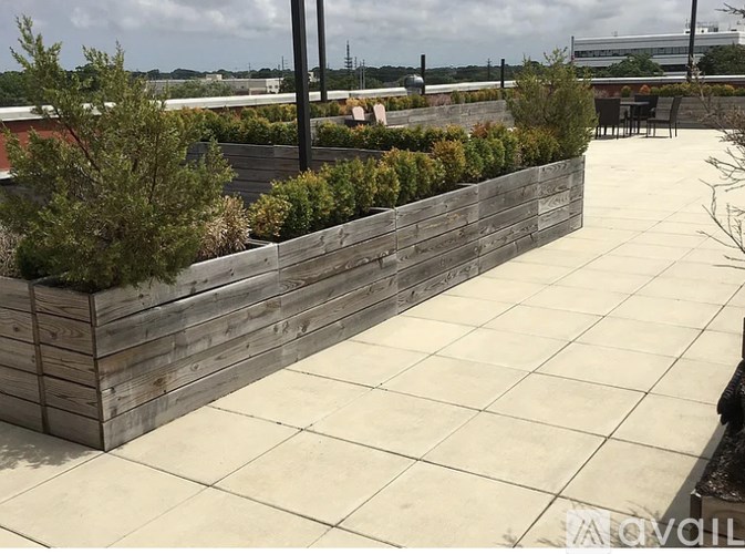 A wooden retaining wall with a tiled floor in front of it.