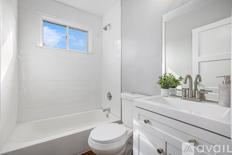 A white bathroom with a toilet, sink, and bathtub.