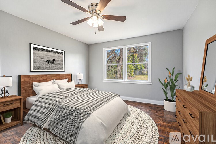 A bedroom with a bed, dresser, and a ceiling fan.