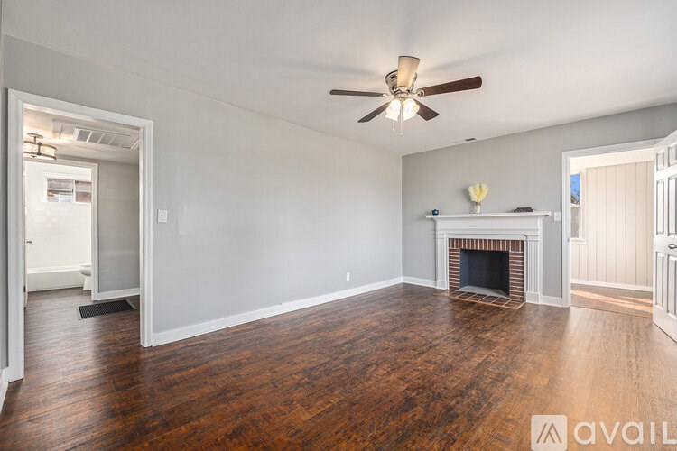 A living room with a fireplace and wood flooring.
