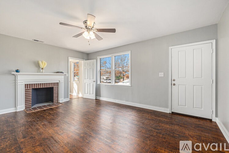 A room with a fireplace and wood flooring.