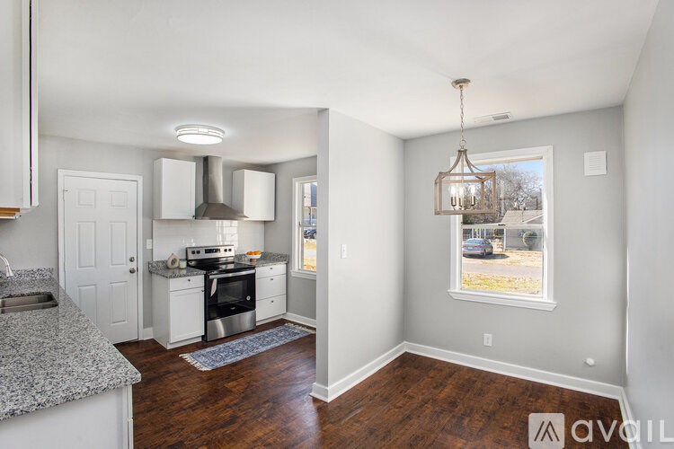 A kitchen with granite countertops and a view of the outdoors through a window.