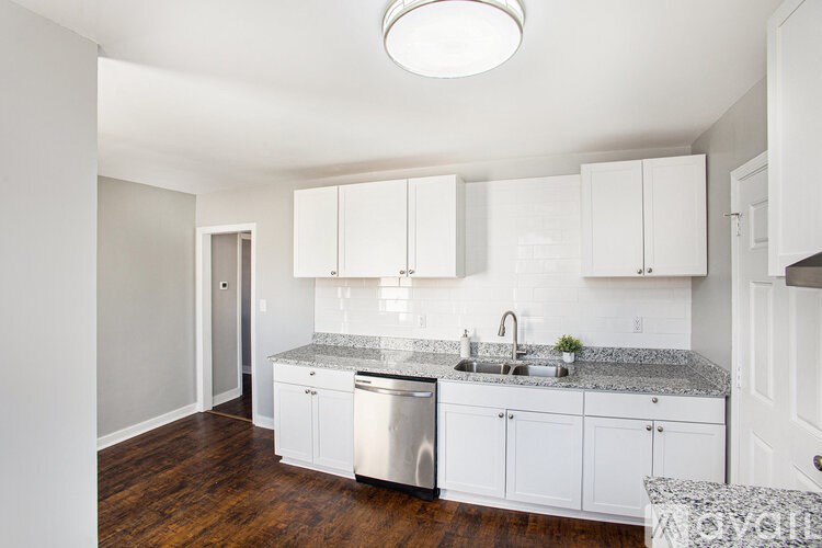 A kitchen with white cabinets and a granite countertop.
