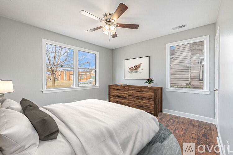A bedroom with a bed, dresser, and window.