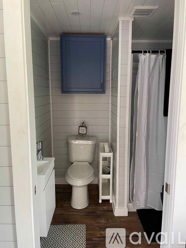 A small bathroom with a toilet, sink, and a shower curtain.