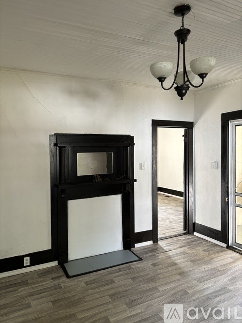 A room with a wooden floor and a chandelier.