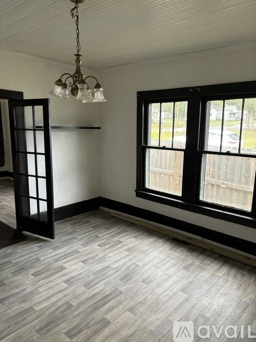 A room with a wooden floor and a chandelier.