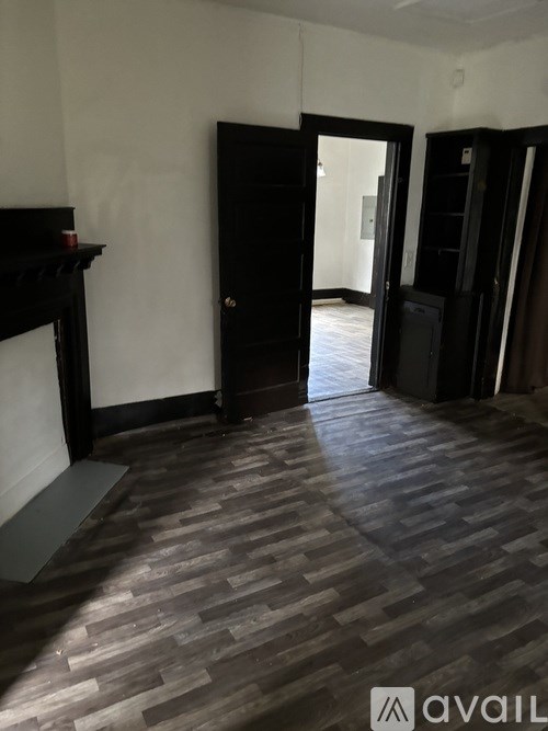 A room with a wooden floor and a black door.