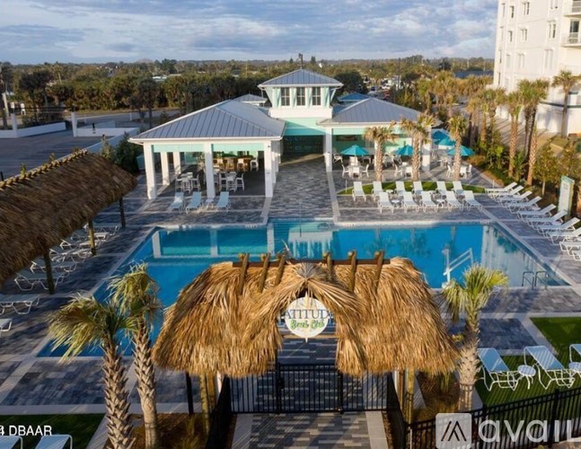 A pool area with a thatched roof structure and a gazebo.