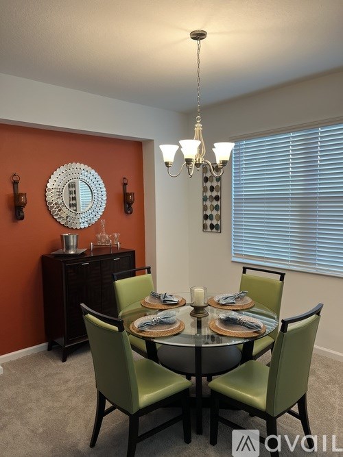 A dining room with a round table and chairs.