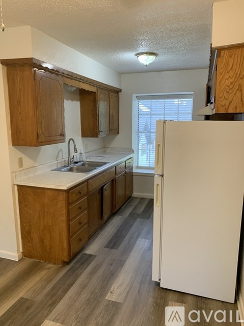 A kitchen with wooden cabinets and a white refrigerator.