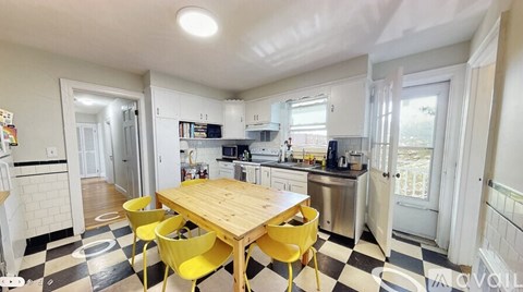 A kitchen with a checkered floor and yellow chairs.
