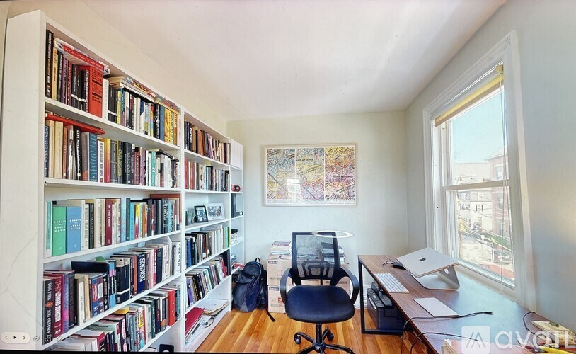 A room with a bookshelf, a desk, and a chair.