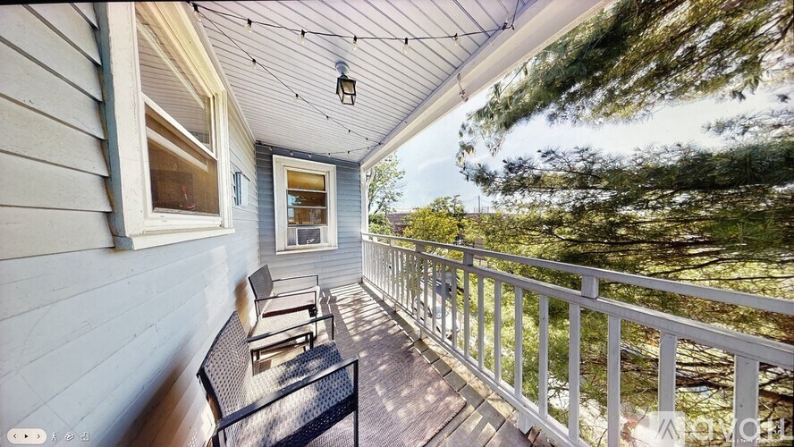 A sunny day on a wooden porch with a white railing.