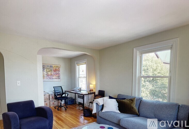 A living room with a couch, chair, and desk.