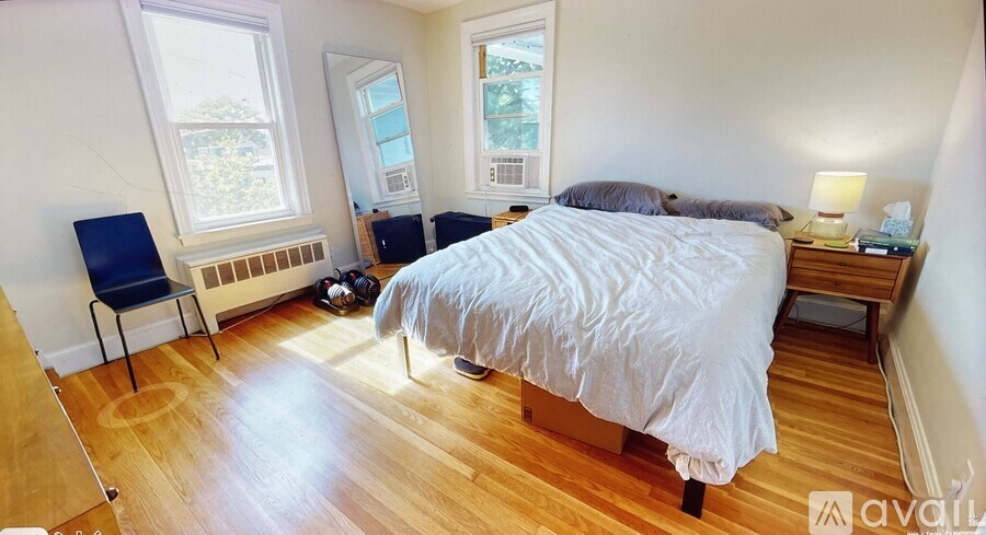 A bedroom with a bed, chair, and window.