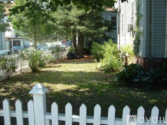 A white picket fence in front of a house.