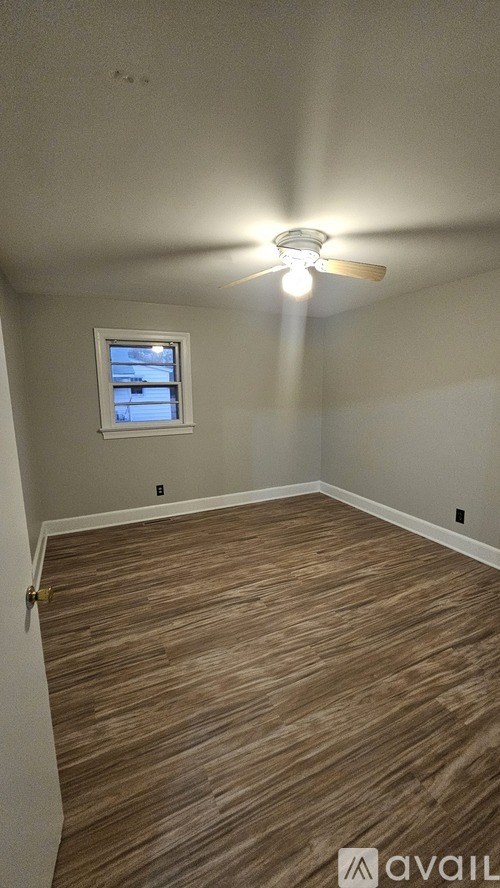 A room with a ceiling fan and a window.
