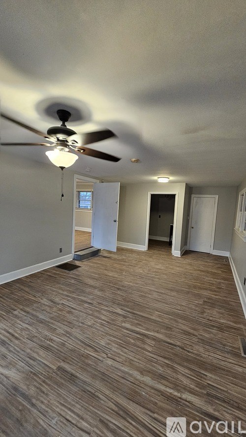 A room with a ceiling fan and light fixture.