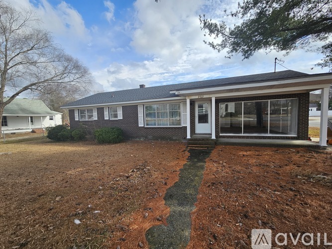 A house with a brick facade and a white door is available for purchase.