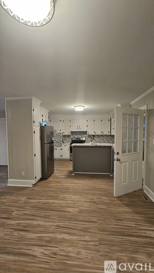 A kitchen with a refrigerator, sink, and cabinets.