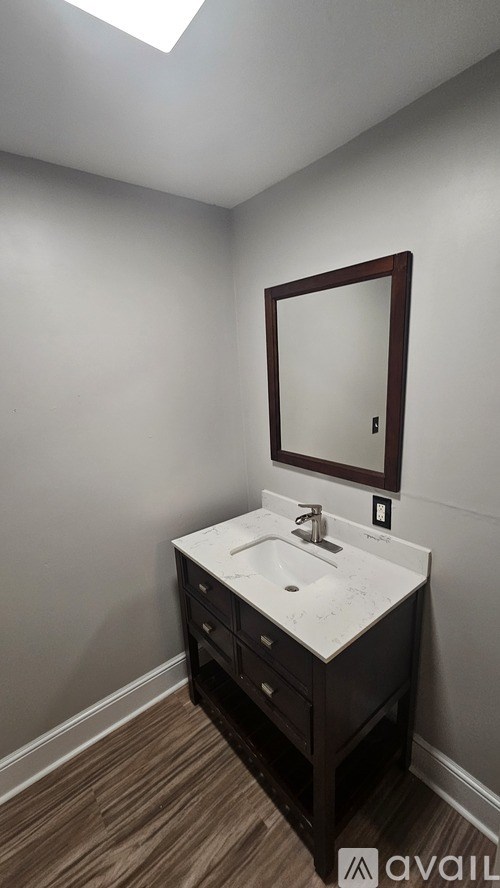 A bathroom with a sink and a mirror.
